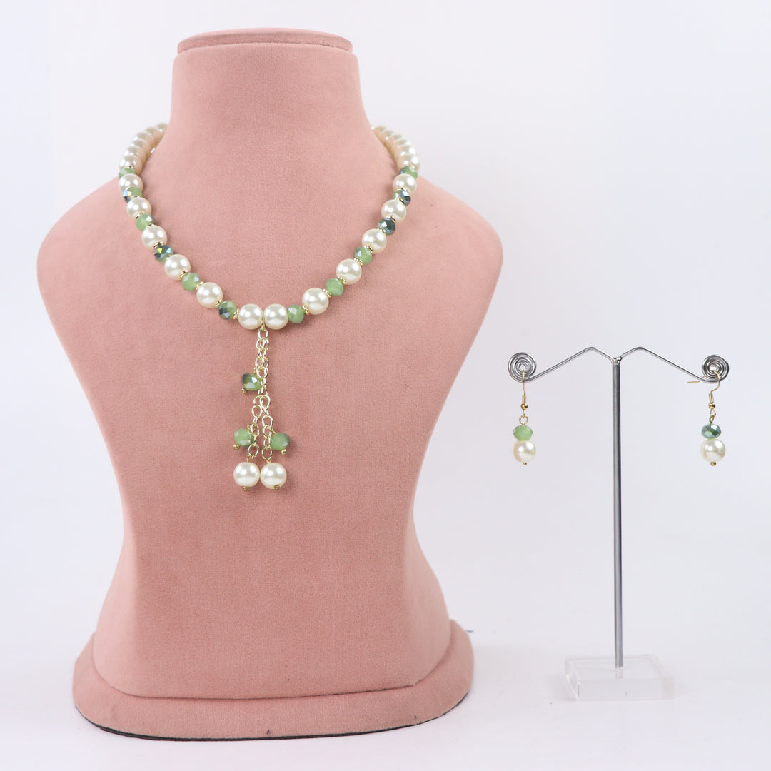 Delemon sage green crystal and cream pearl Y-drop necklace with matching drop earrings on display mannequin.