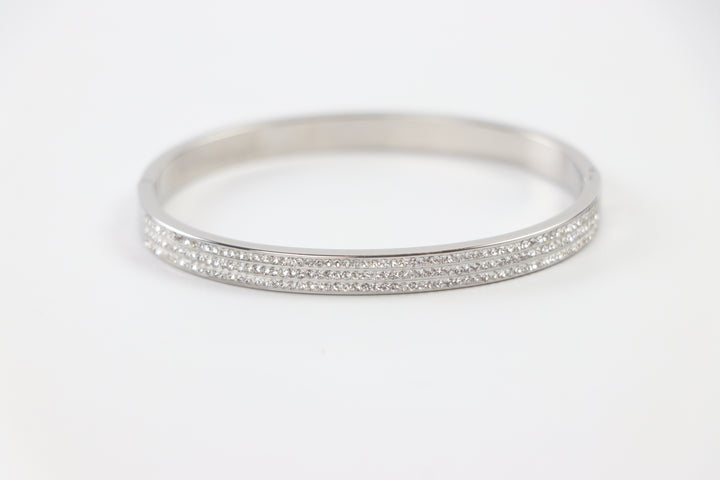 Delemon silver rigid bangle bracelet featuring three rows of clear pavé crystals in waterproof 316L stainless steel