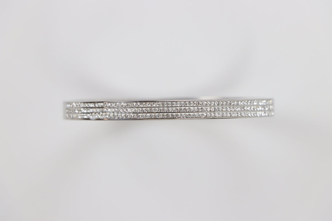 Delemon silver rigid bangle bracelet featuring three rows of clear pavé crystals in waterproof 316L stainless steel