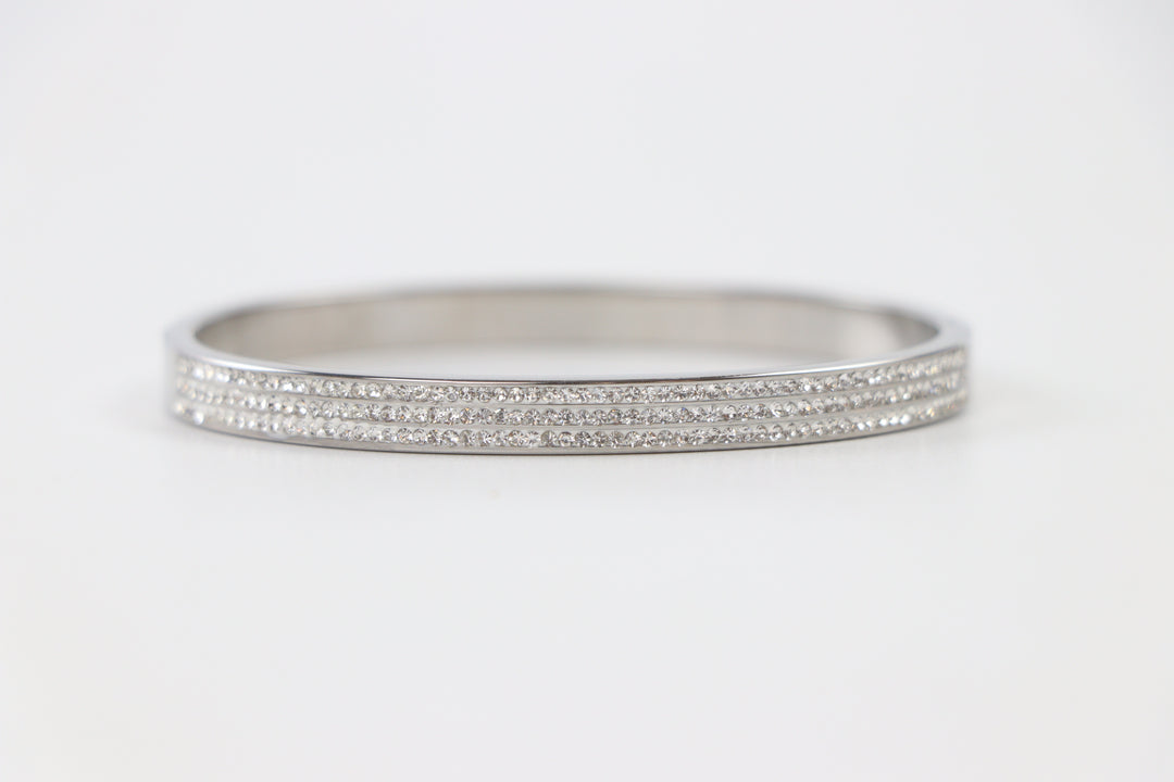 Delemon silver rigid bangle bracelet featuring three rows of clear pavé crystals in waterproof 316L stainless steel