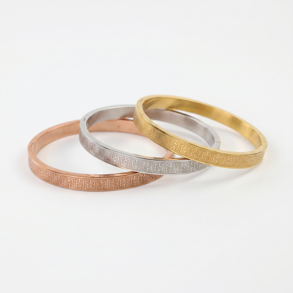 Delemon three-piece rigid bangle stack featuring yellow gold, rose gold, and silver Greek key engraved geometric bracelets in waterproof 316L stainless steel