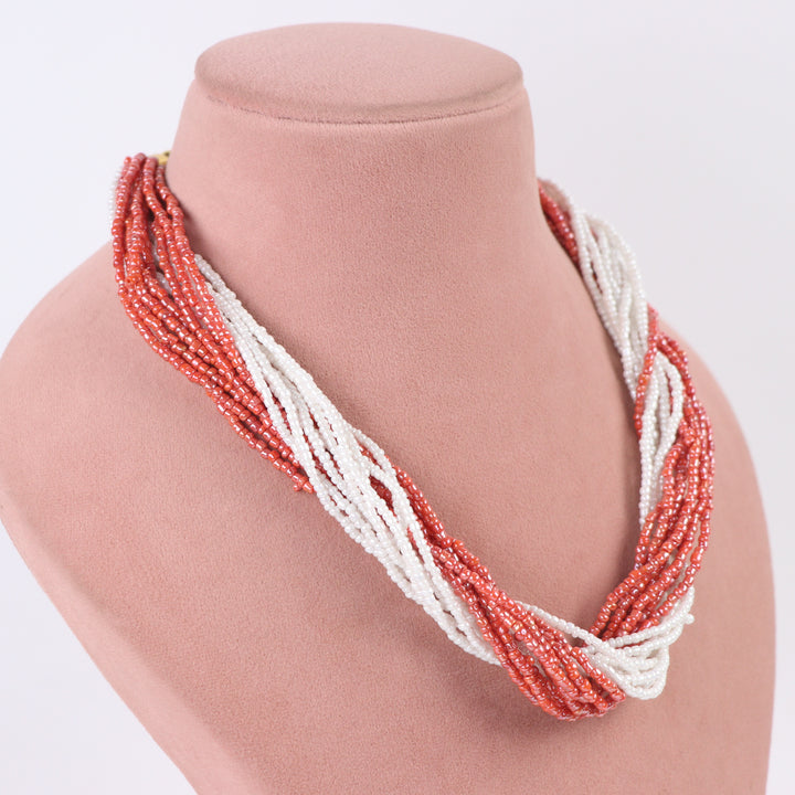 Terracotta orange-pink and white twisted multi-strand seed bead necklace on a mannequin - Delemon Collection.