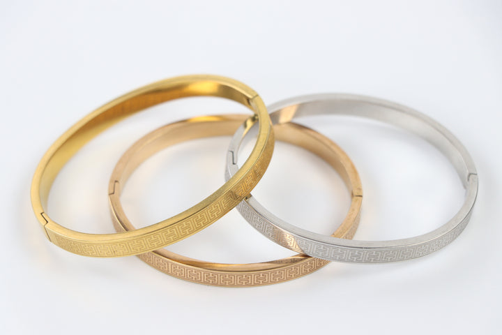 elemon three-piece rigid bangle stack featuring yellow gold, rose gold, and silver Greek key engraved geometric bracelets in waterproof 316L stainless steel