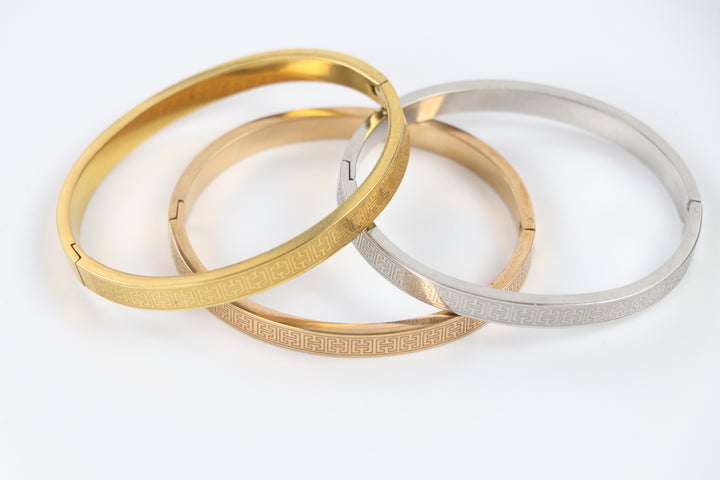 elemon three-piece rigid bangle stack featuring yellow gold, rose gold, and silver Greek key engraved geometric bracelets in waterproof 316L stainless steel