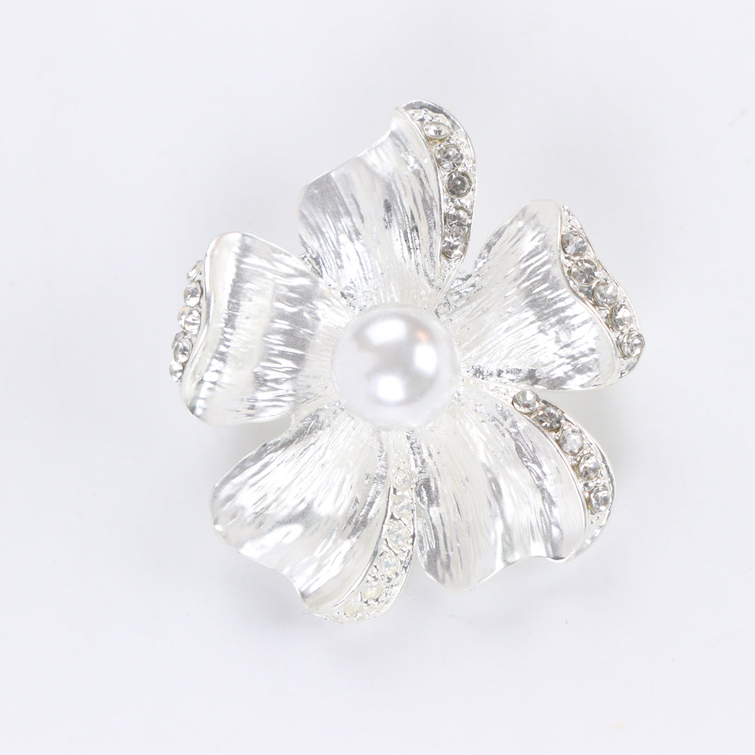 Brushed silver-tone flower brooch pin with rhinestone-trimmed petals and a large center faux pearl on a white background by Delemon