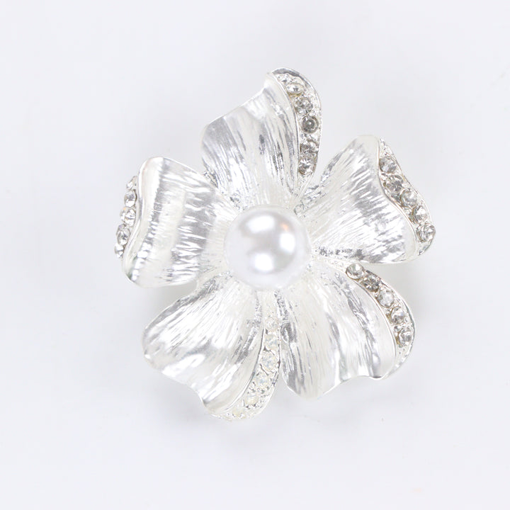 Brushed silver-tone flower brooch pin with rhinestone-trimmed petals and a large center faux pearl on a white background by Delemon