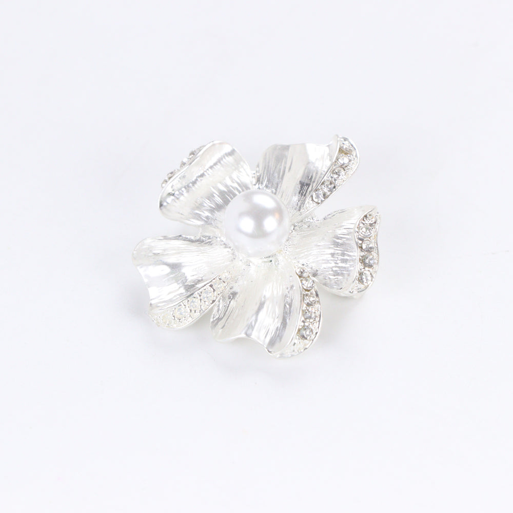 Brushed silver-tone flower brooch pin with rhinestone-trimmed petals and a large center faux pearl on a white background by Delemon