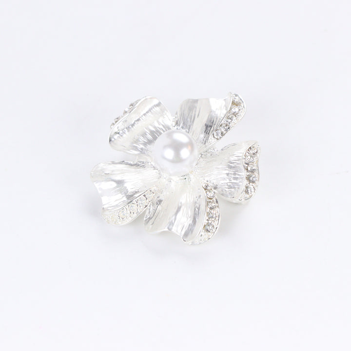 Brushed silver-tone flower brooch pin with rhinestone-trimmed petals and a large center faux pearl on a white background by Delemon