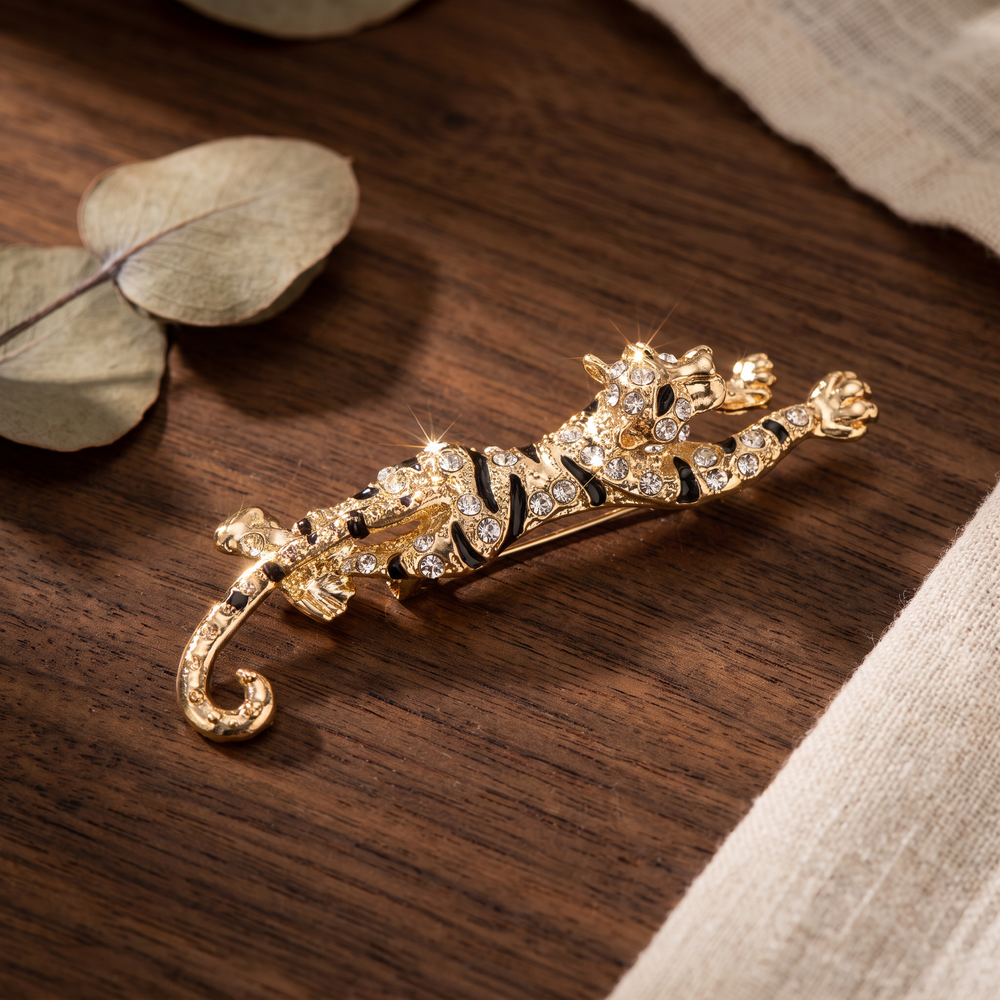 Gold prowling tiger brooch pin encrusted with clear pavé crystals and black enamel stripes 