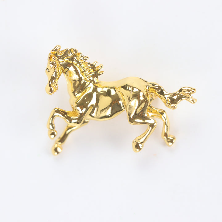 Shiny gold galloping horse brooch pin isolated against a white background by Delemon