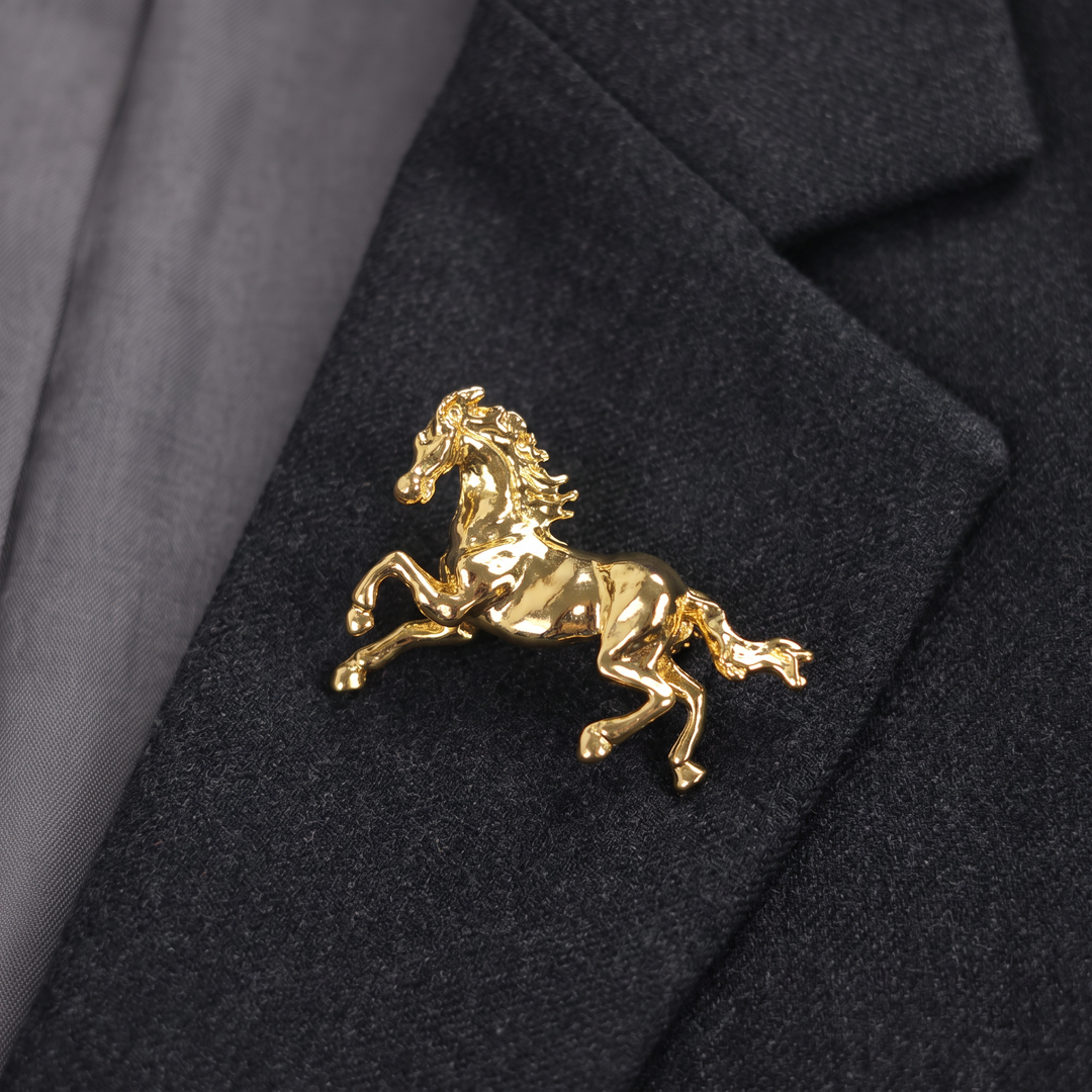Shiny gold galloping horse brooch pin isolated against a white background by Delemon