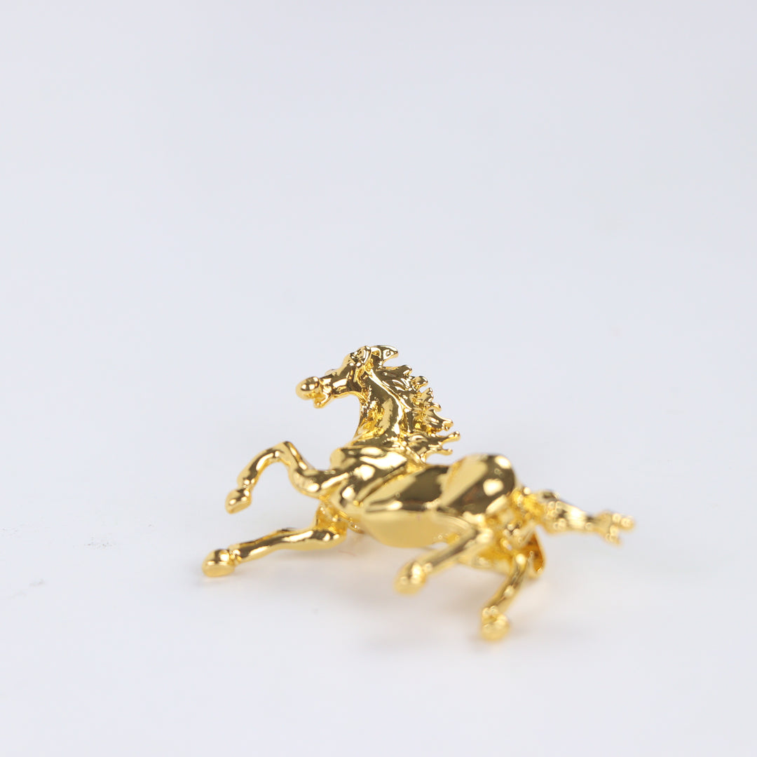 Shiny gold galloping horse brooch pin isolated against a white background by Delemon