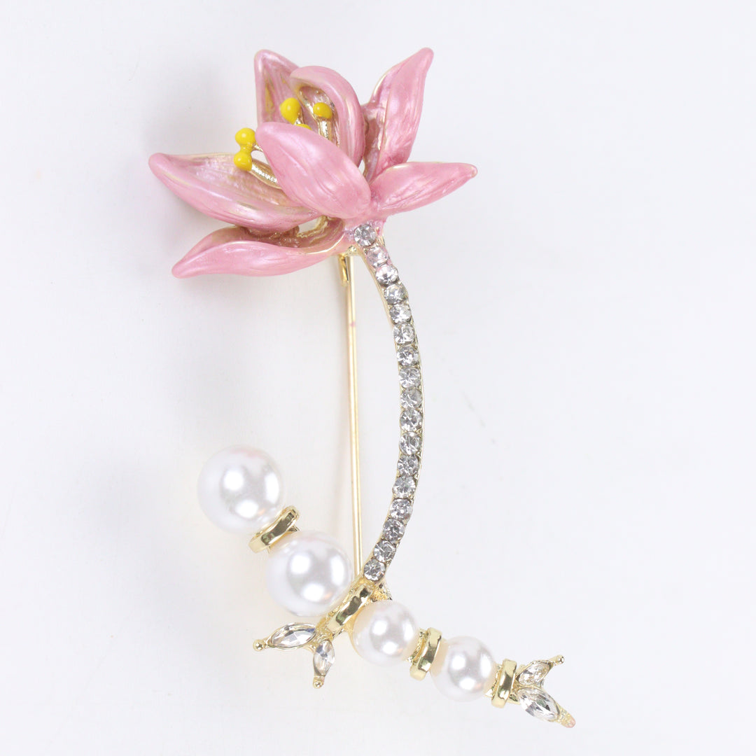 Gold-tone brooch pin featuring a pink enamel lily flower, pavé rhinestone stem, and a curved strand of white pearls 