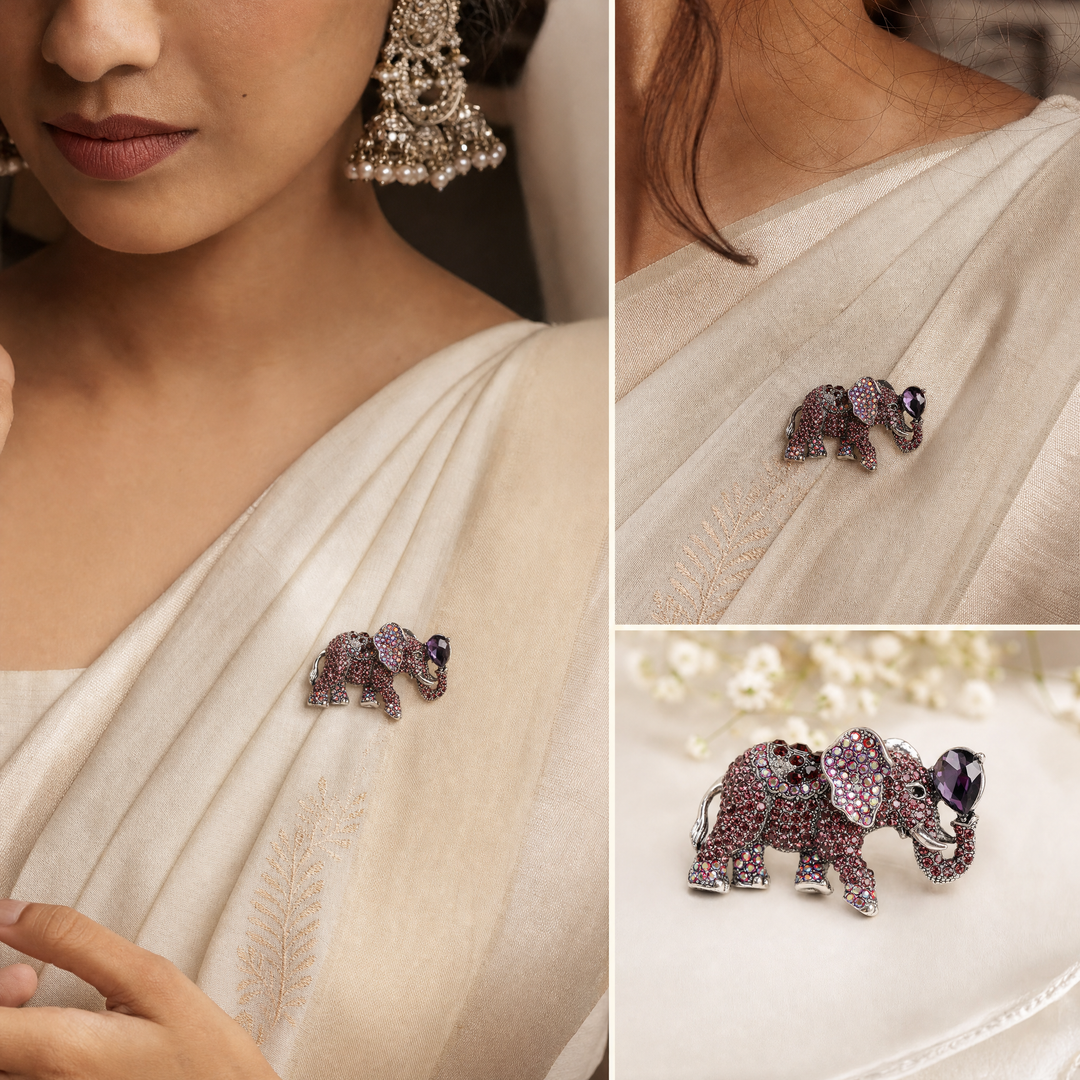 Antique silver-tone elephant brooch pin pavé-set with purple and iridescent crystals holding a pear-cut purple jewel in its raised trunk on a white background by Delemon