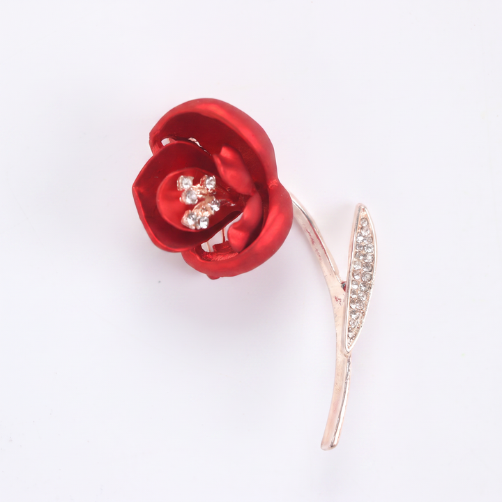 Matte red flower brooch pin with crystal stamen and crystal leaf on a rose gold 