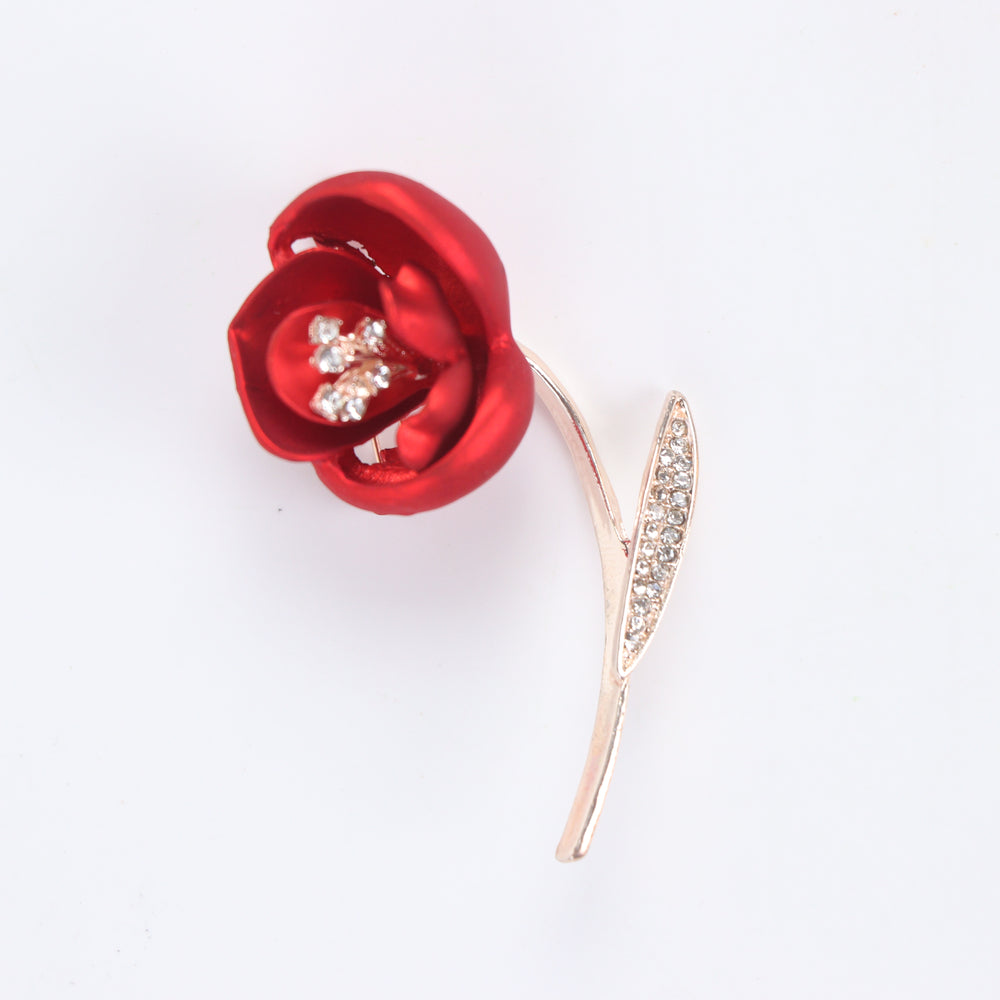 Matte red flower brooch pin with crystal stamen and crystal leaf on a rose gold stem against a white background by Delemon