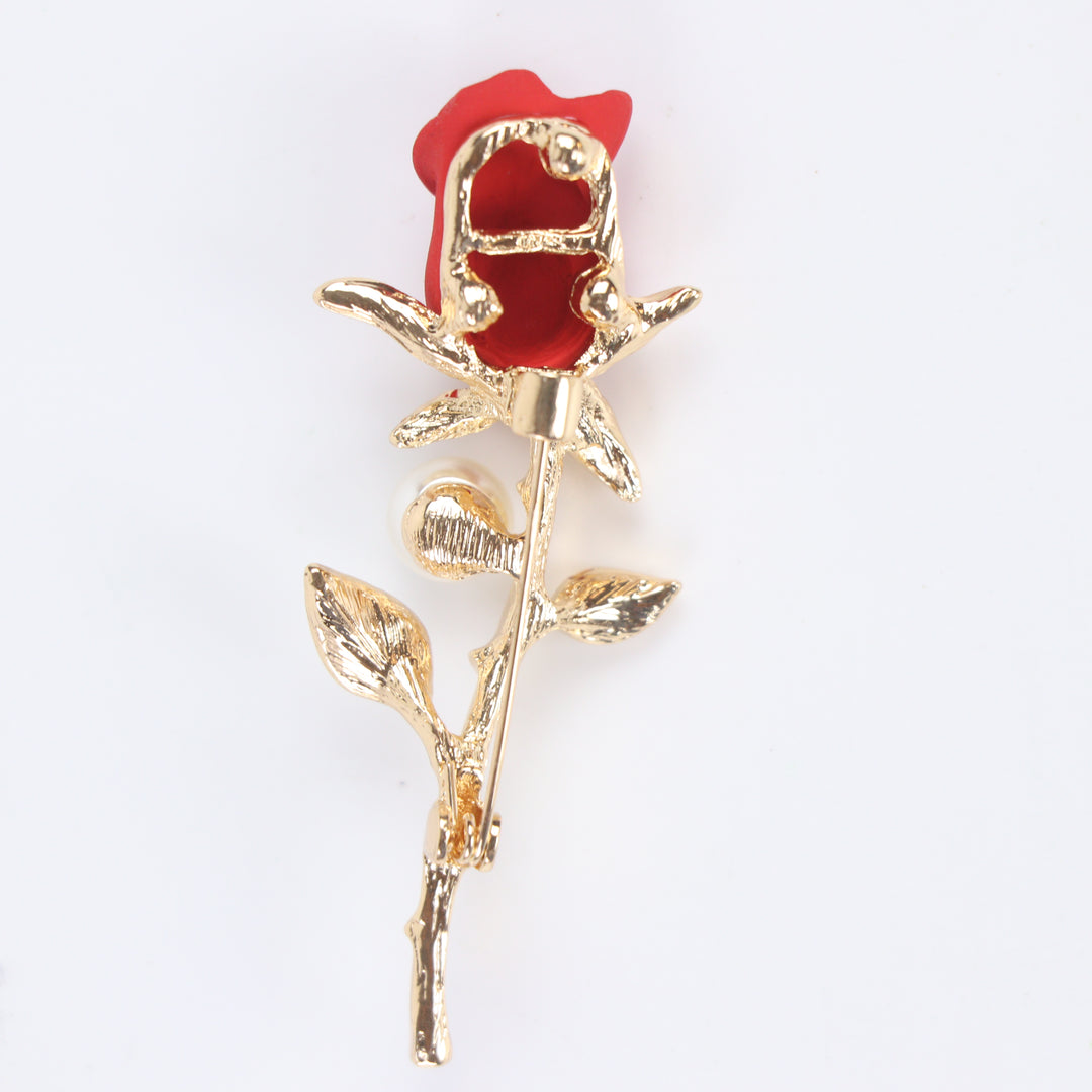 Matte red rose flower brooch pin with a pearl accent and pave crystal leaves on a gold stem against a white background by Delemon