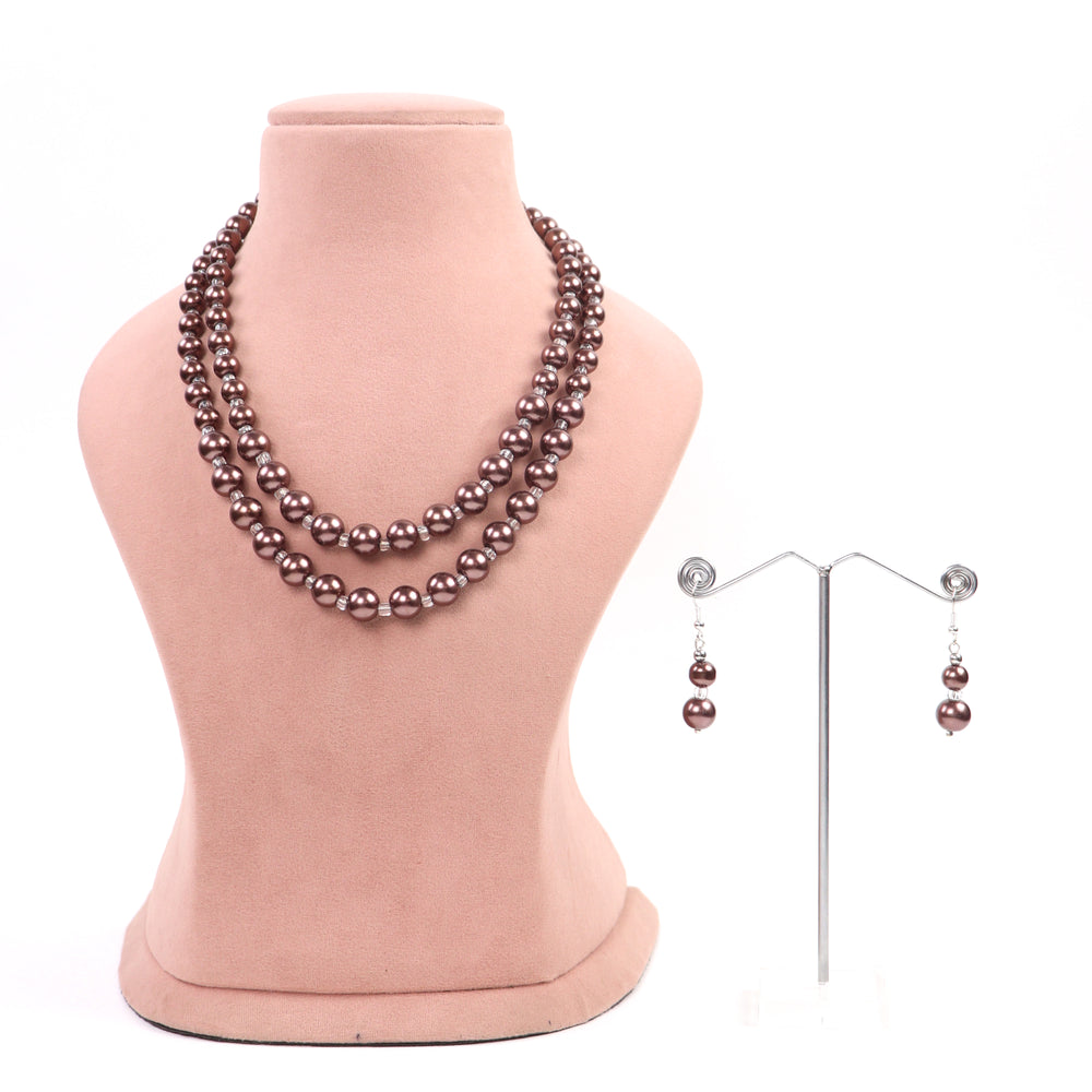 Text: Mocha metallic chocolate brown double-strand glass pearl necklace and matching earrings on a pink display - Delemon Collection.