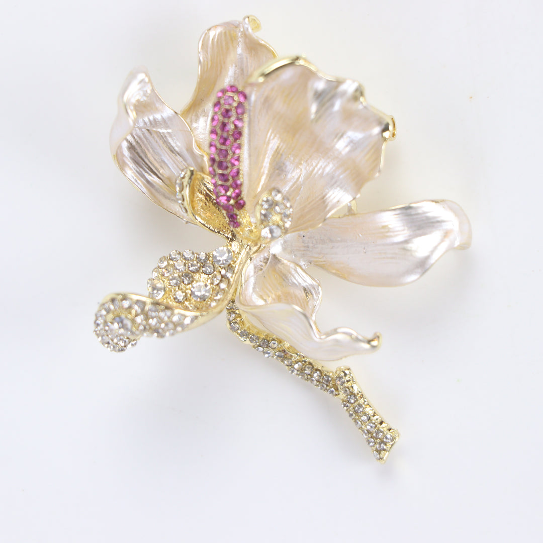 Pearlescent cream enamel flower brooch pin with pink and clear crystal accents against a white background by Delemon