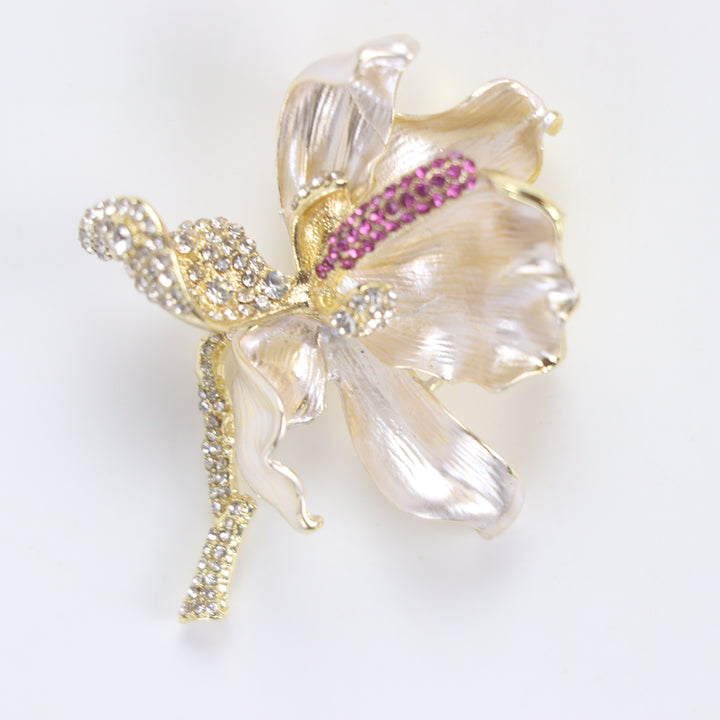 Pearlescent cream enamel flower brooch pin with pink and clear crystal accents against a white background by Delemon