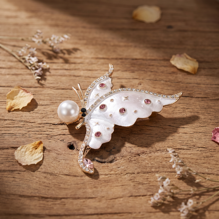 Pearlescent white enamel butterfly brooch pin with a large pearl accent and pink crystals