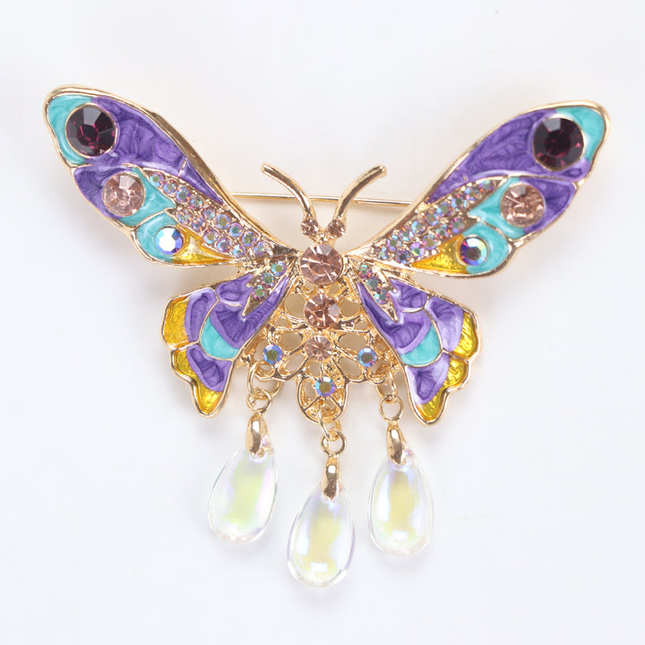 Colorful purple and turquoise enamel butterfly brooch pin with sparkling crystals and three dangling teardrop beads on a white background by Delemon