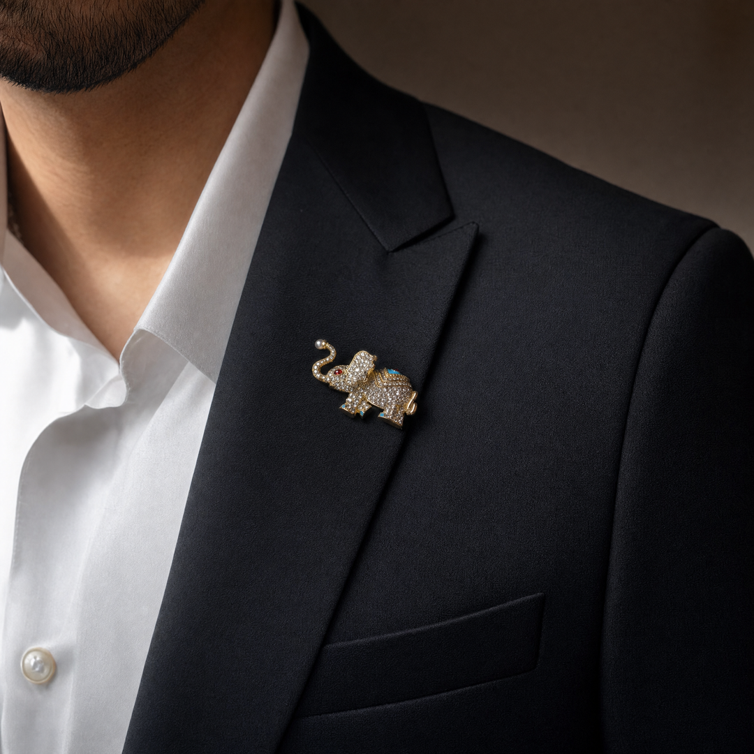 Sparkling gold elephant brooch pin with paved crystals, turquoise enamel saddle, and a pearl trunk tip