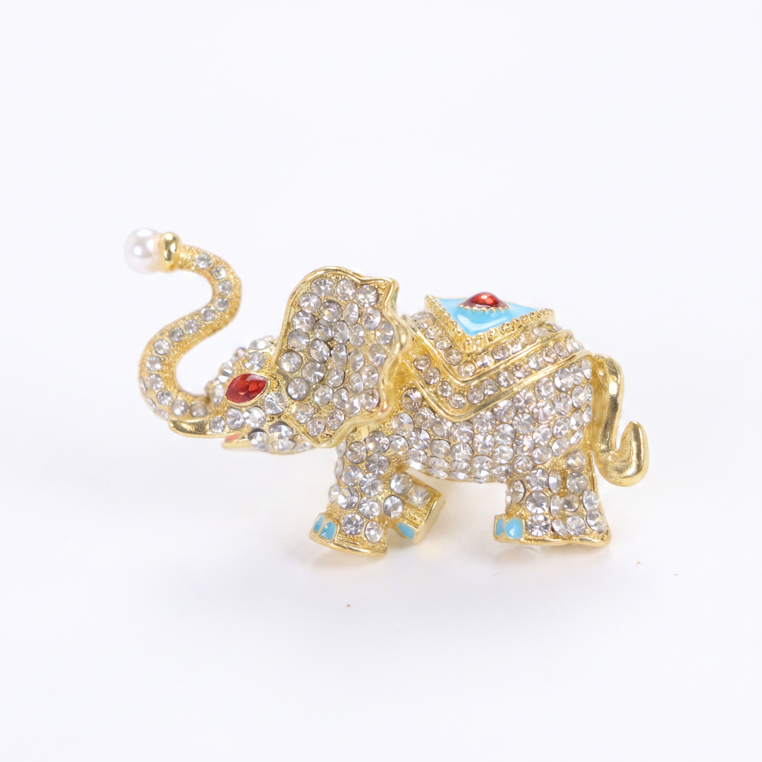 Sparkling gold elephant brooch pin with paved crystals, turquoise enamel saddle, and a pearl trunk tip