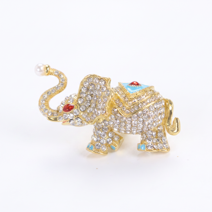 Sparkling gold elephant brooch pin with paved crystals, turquoise enamel saddle, and a pearl trunk tip