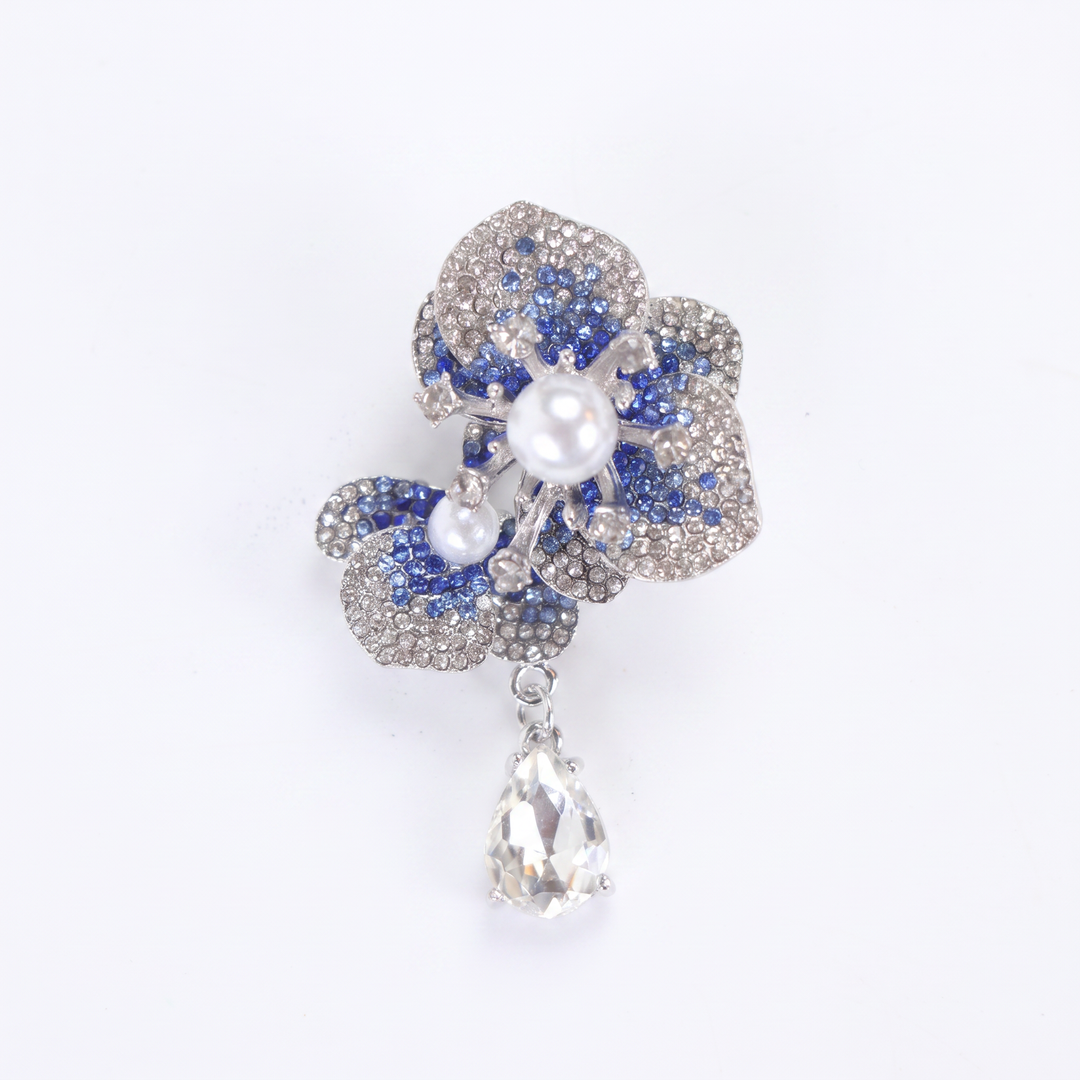 Silver-tone sapphire blue crystal orchid flower brooch pin with pearl centers and a dangling teardrop crystal 