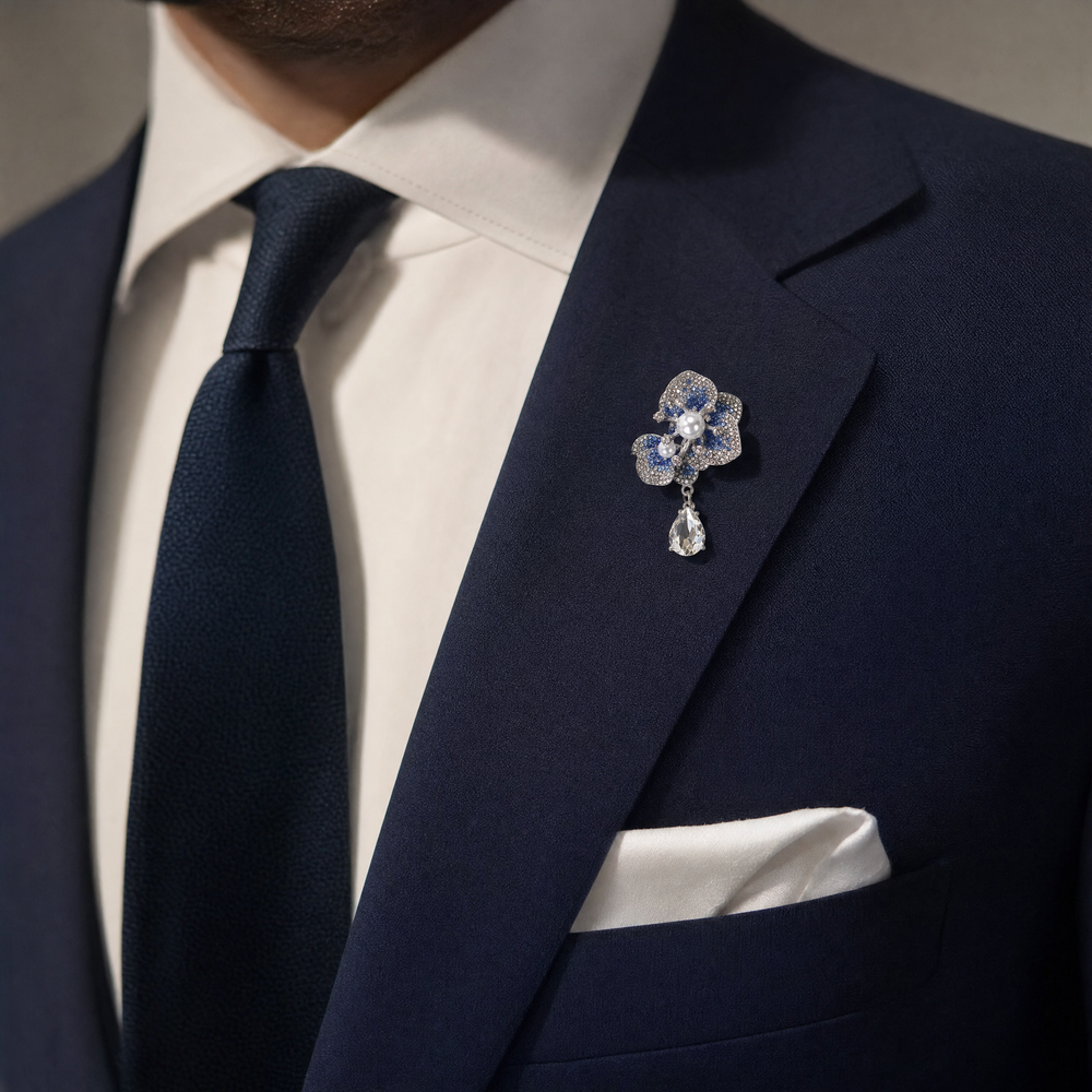 Silver-tone sapphire blue crystal orchid flower brooch pin with pearl centers and a dangling teardrop crystal 