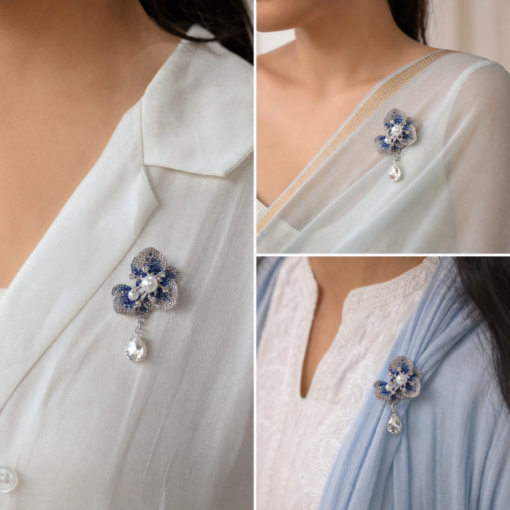Silver-tone sapphire blue crystal orchid flower brooch pin with pearl centers and a dangling teardrop crystal 