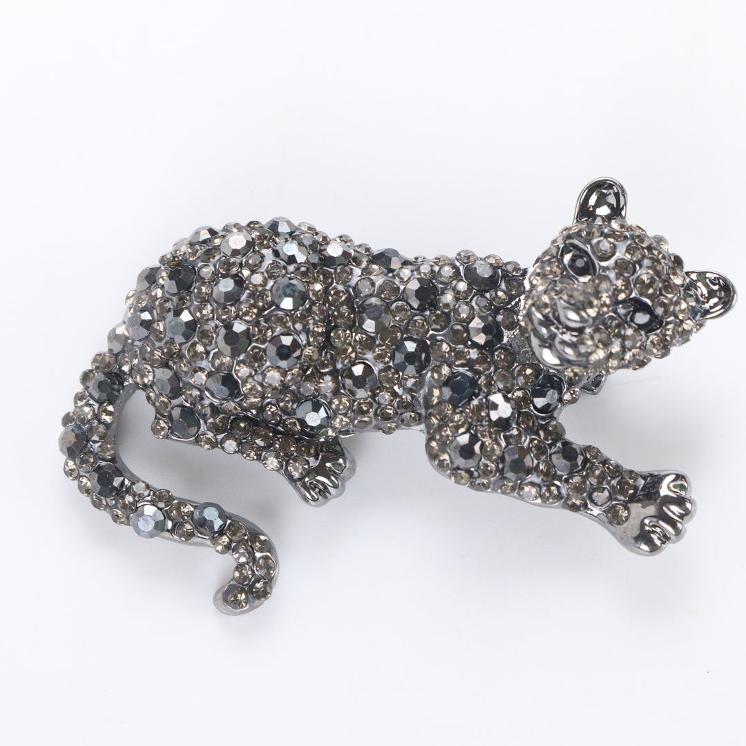 Gunmetal-tone crouching panther brooch pin fully pavé-set with dark hematite and smoky crystals on a white background by Delemon