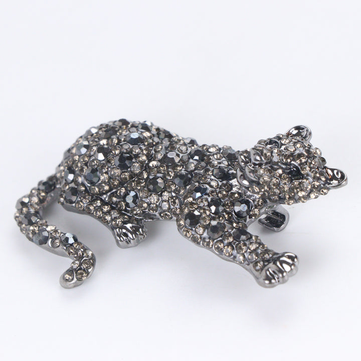 Gunmetal-tone crouching panther brooch pin fully pavé-set with dark hematite and smoky crystals on a white background by Delemon