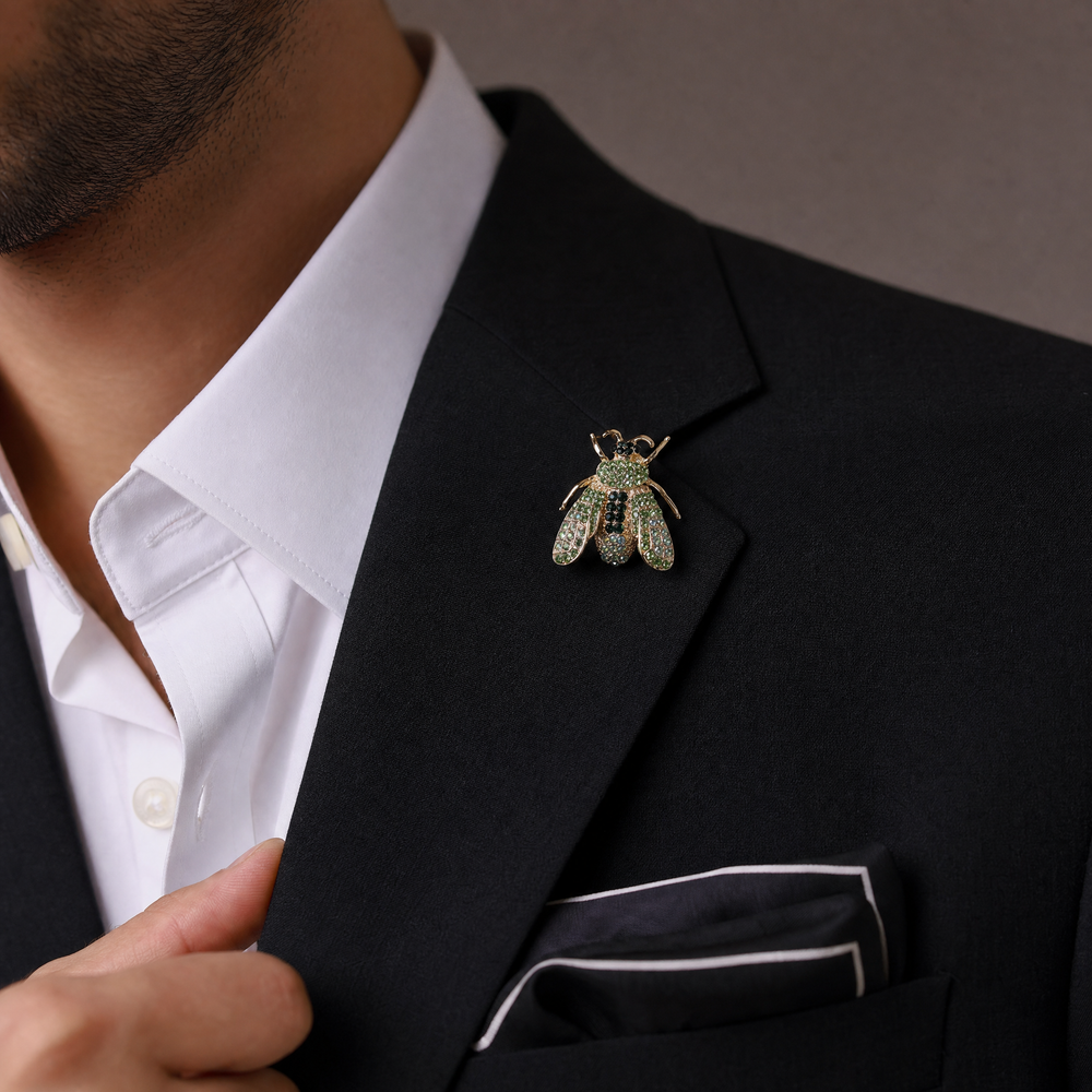 Gold-tone honeybee brooch pin encrusted with peridot and emerald green crystals on a white background by Delemon