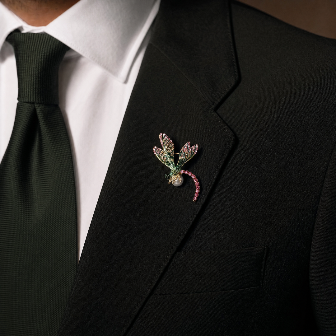 Gold-tone dragonfly brooch pin with pink and green rhinestone wings, fuchsia crystal tail, and a white pearl 