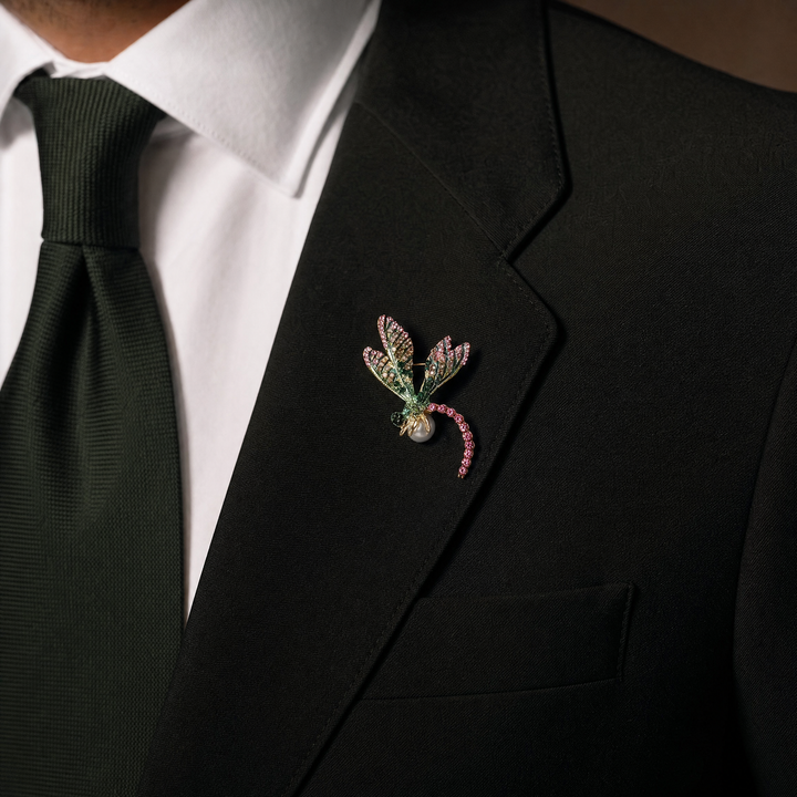 Gold-tone dragonfly brooch pin with pink and green rhinestone wings, fuchsia crystal tail, and a white pearl 