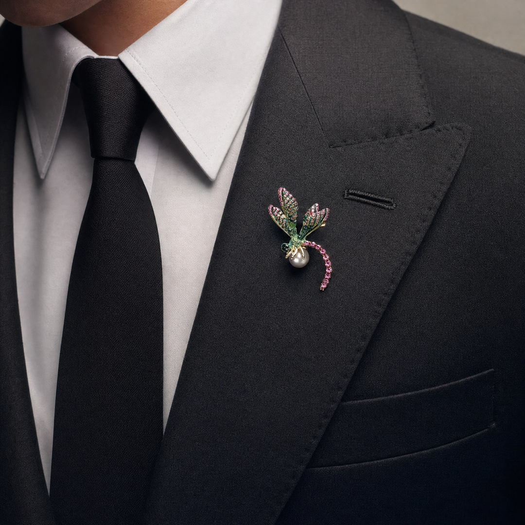 Gold-tone dragonfly brooch pin with pink and green rhinestone wings, fuchsia crystal tail, and a white pearl 