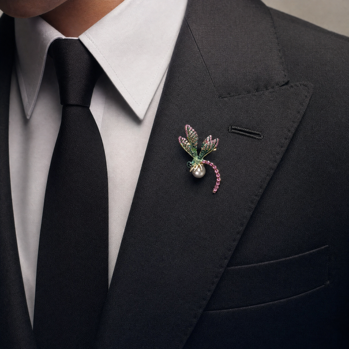 Gold-tone dragonfly brooch pin with pink and green rhinestone wings, fuchsia crystal tail, and a white pearl 