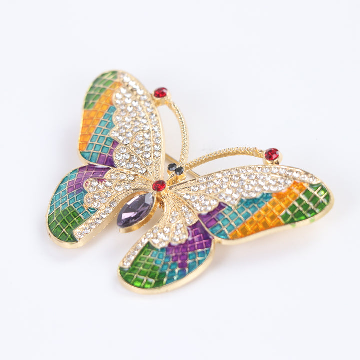 Colorful stained-glass style butterfly brooch pin with clear crystals and a purple marquise center stone against a white background by Delemon