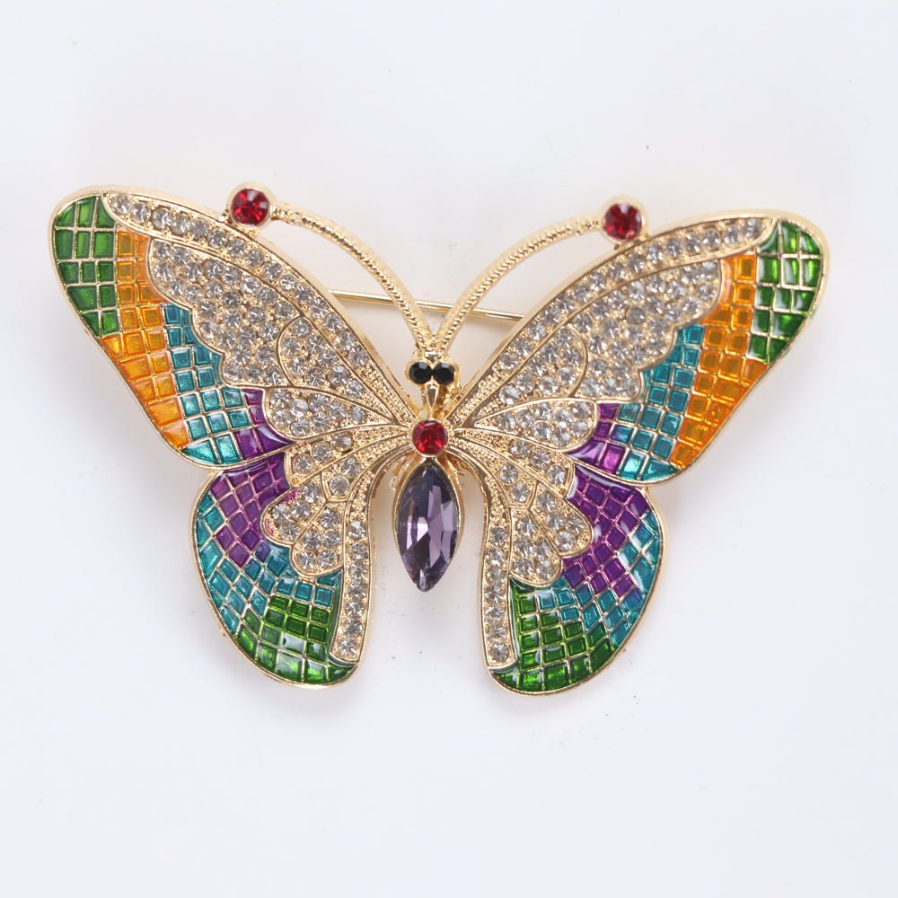 Colorful stained-glass style butterfly brooch pin with clear crystals and a purple marquise center stone against a white background by Delemon