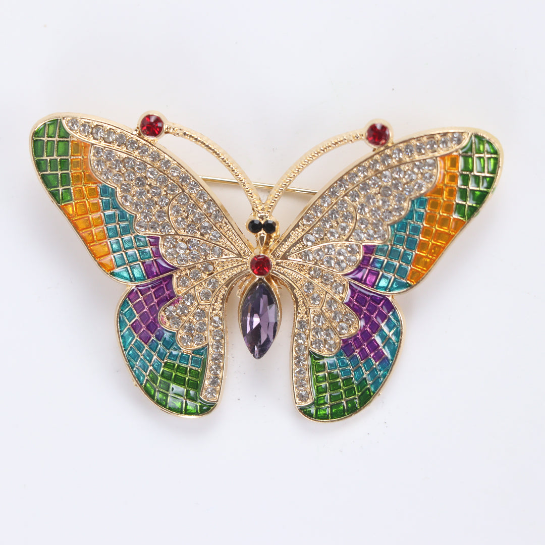 Colorful stained-glass style butterfly brooch pin with clear crystals and a purple marquise center stone against a white background by Delemon