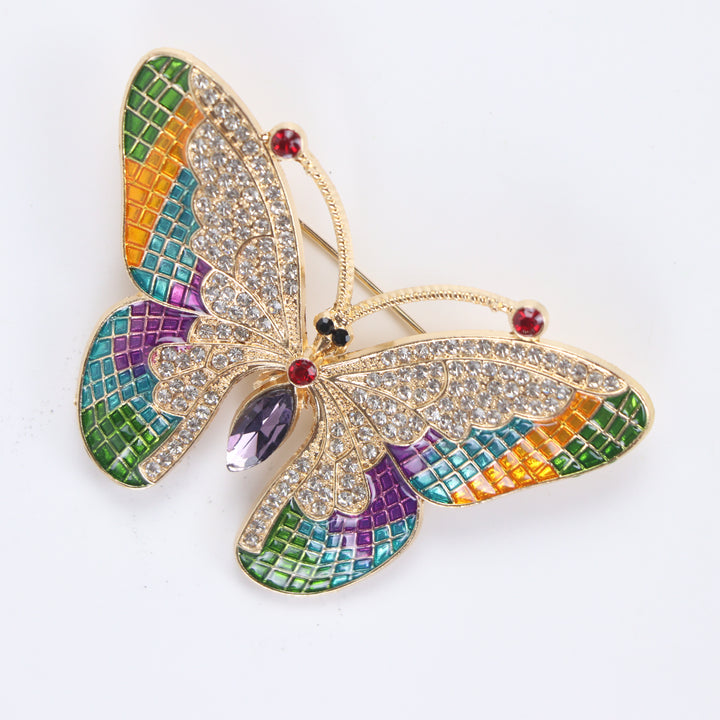 Colorful stained-glass style butterfly brooch pin with clear crystals and a purple marquise center stone against a white background by Delemon