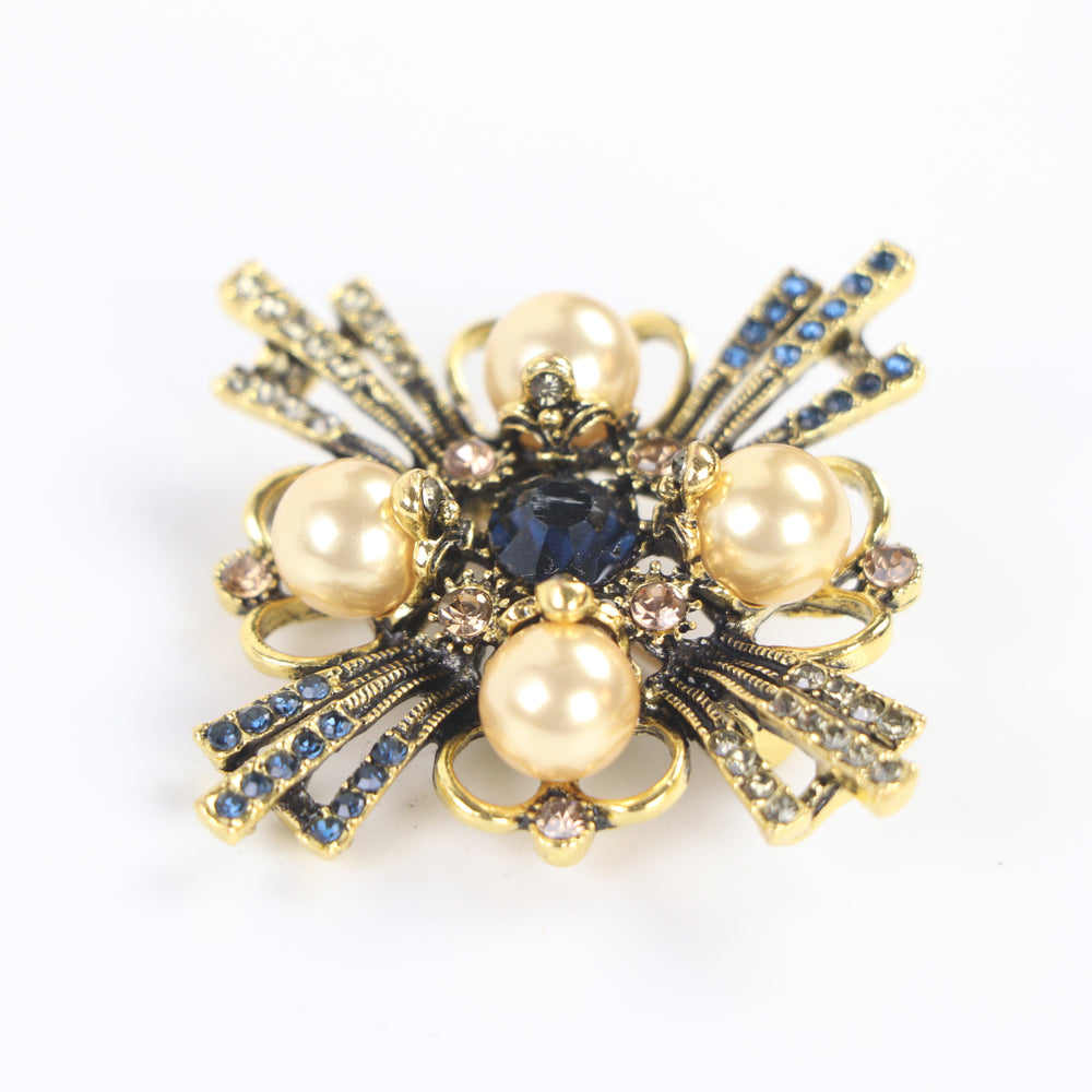 Vintage antique gold baroque cross brooch pin set with four pearl cabochons and multi-colored crystals on a white background by Delemon