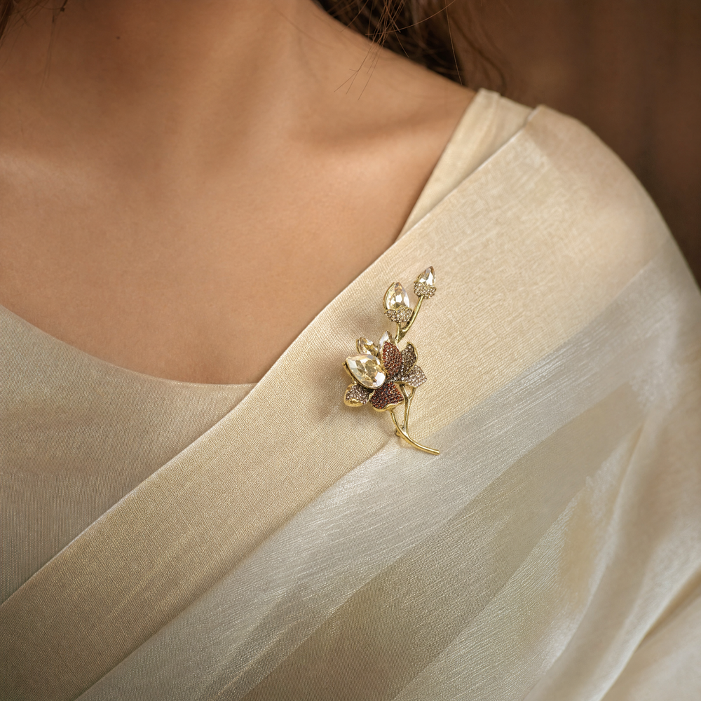 Antiqued gold-tone floral branch brooch pin featuring champagne crystals, topaz rhinestones, and crystal buds 