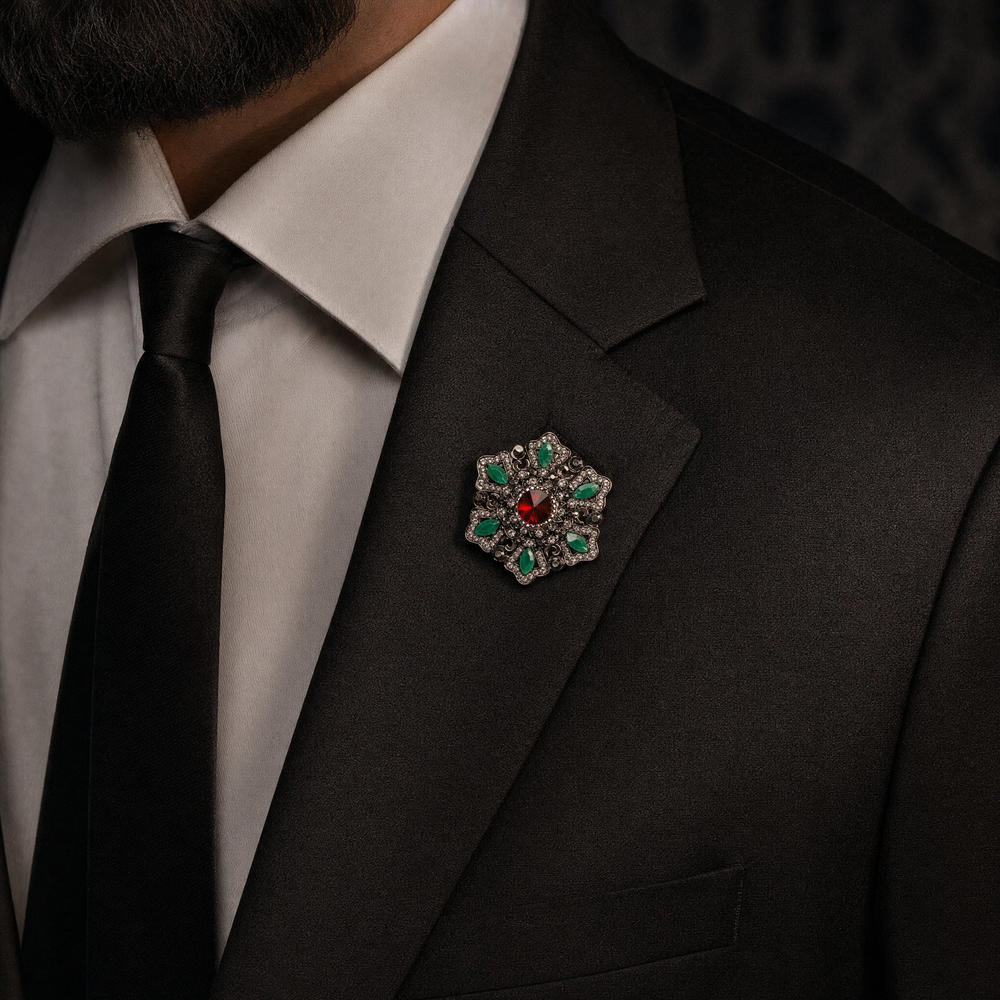 Antique silver-tone filigree starburst medallion brooch pin featuring a ruby red crystal center and jade green marquise accents 