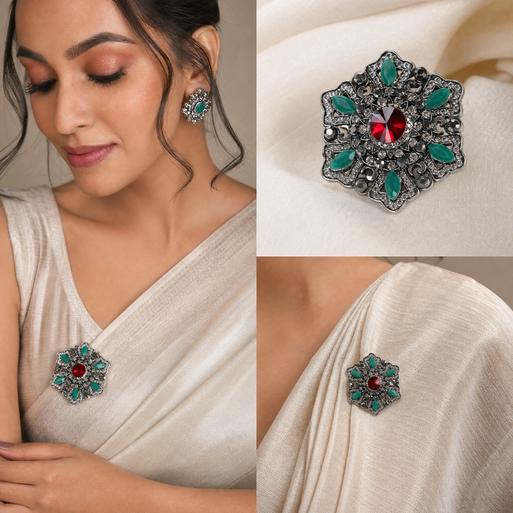 Antique silver-tone filigree starburst medallion brooch pin featuring a ruby red crystal center and jade green marquise accents 